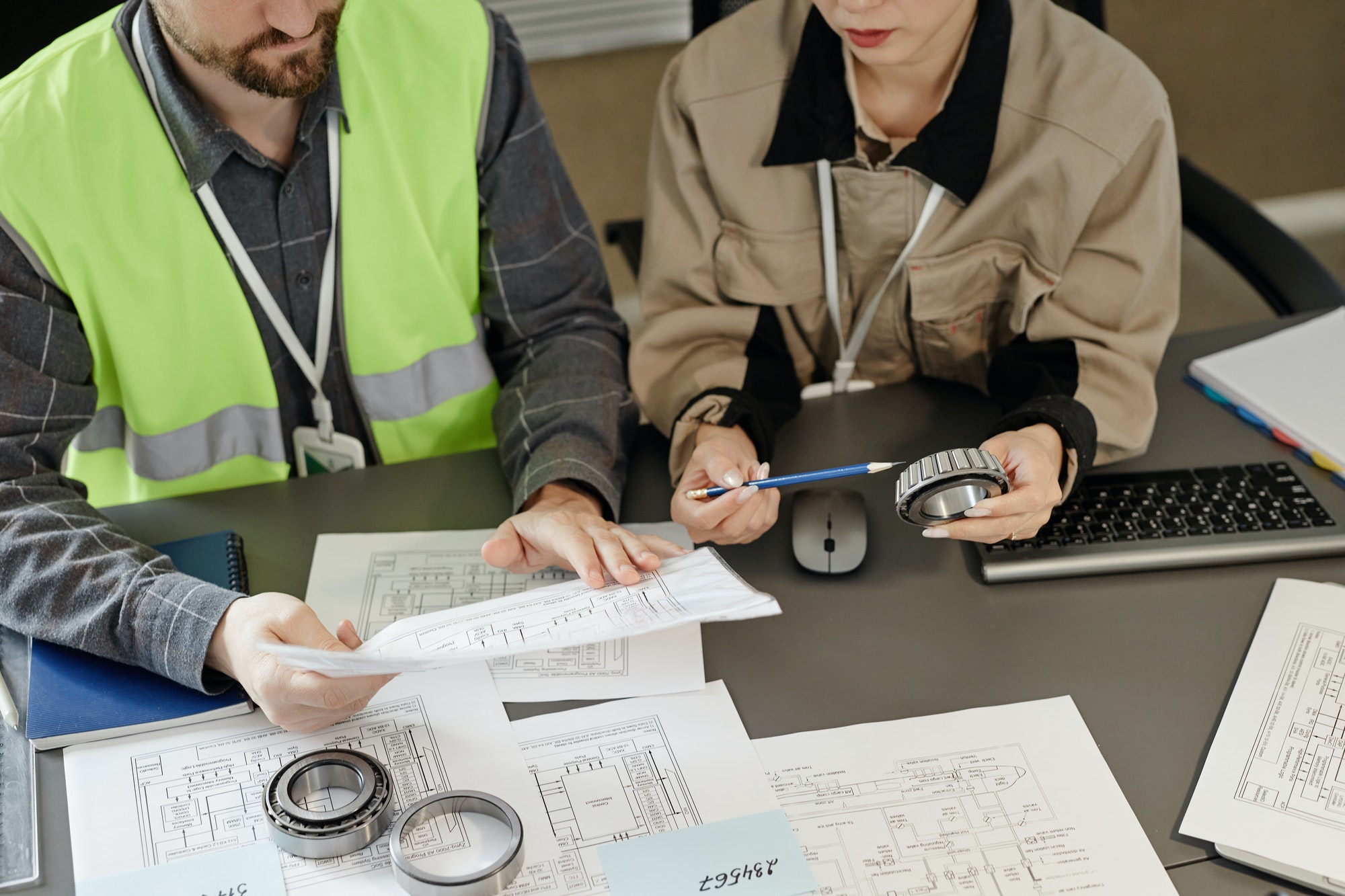 Top view at two engineers designing blueprints at workplace in office